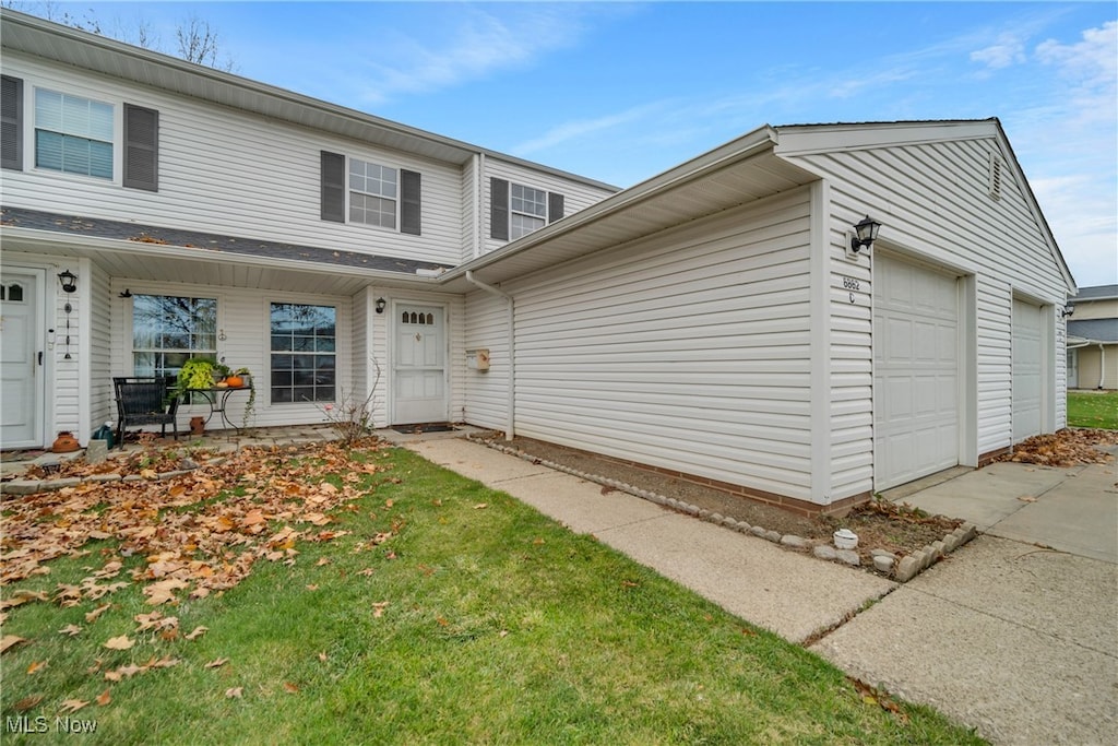 view of front of home with a porch, a garage, and a front lawn