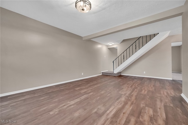 unfurnished living room featuring a textured ceiling and dark wood-type flooring