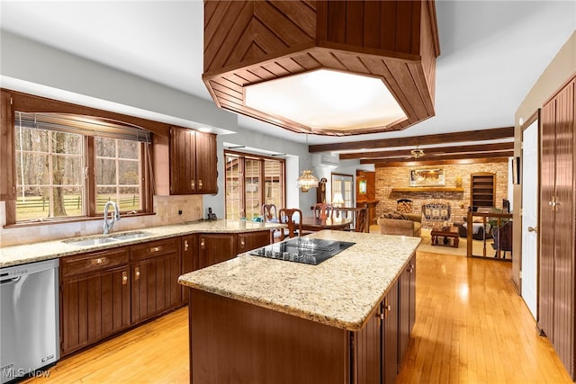 kitchen featuring light wood-type flooring, black electric cooktop, sink, dishwasher, and a kitchen island