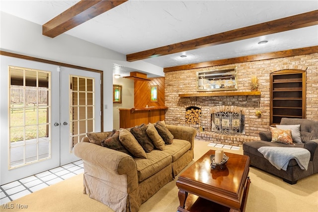 living room with a brick fireplace, beam ceiling, light tile patterned floors, and french doors