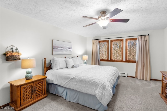 bedroom featuring a textured ceiling, light colored carpet, ceiling fan, and a baseboard heating unit