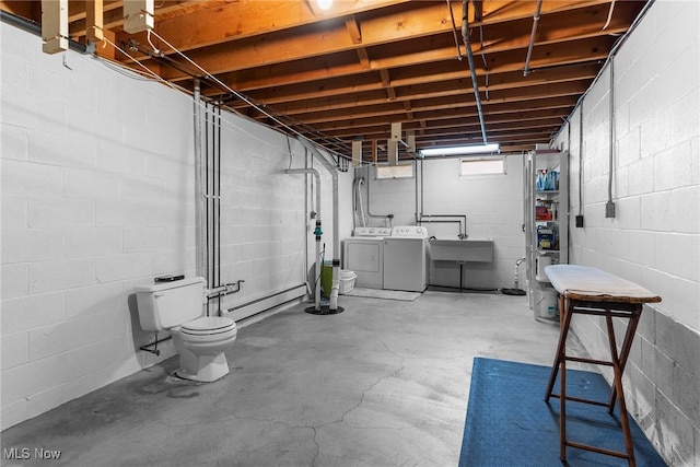 basement with washing machine and clothes dryer, sink, and a baseboard radiator