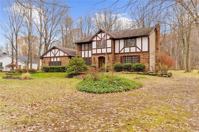 tudor-style house featuring a front yard