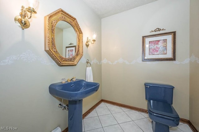 bathroom featuring tile patterned flooring and a textured ceiling