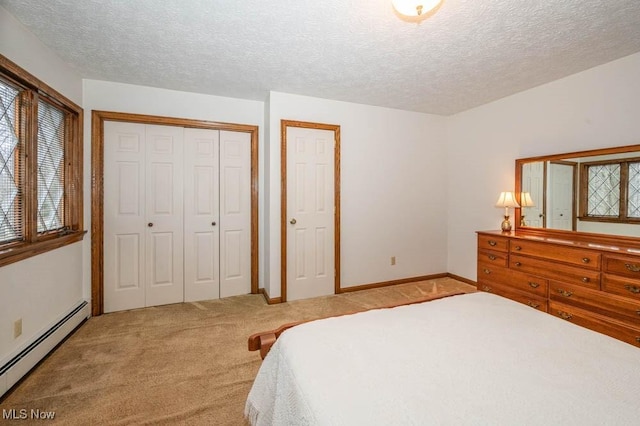 carpeted bedroom featuring a textured ceiling and a baseboard heating unit