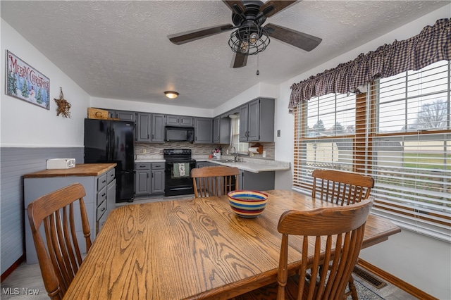 dining area with a textured ceiling, ceiling fan, and sink