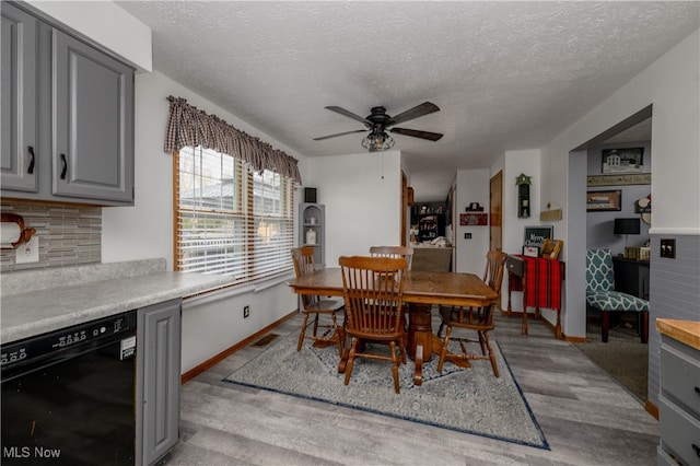 dining area featuring a textured ceiling, light wood-type flooring, and ceiling fan