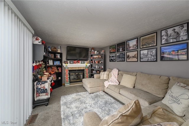 carpeted living room with a fireplace and a textured ceiling