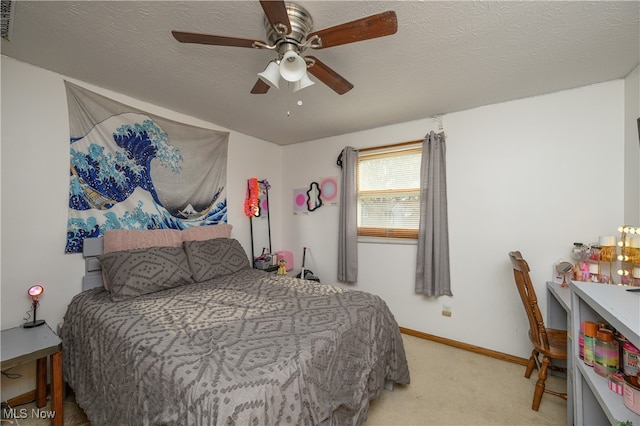 carpeted bedroom featuring ceiling fan and a textured ceiling