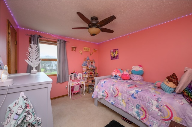 bedroom featuring a textured ceiling, light colored carpet, and ceiling fan