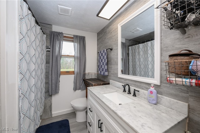 bathroom with hardwood / wood-style floors, vanity, and tile walls