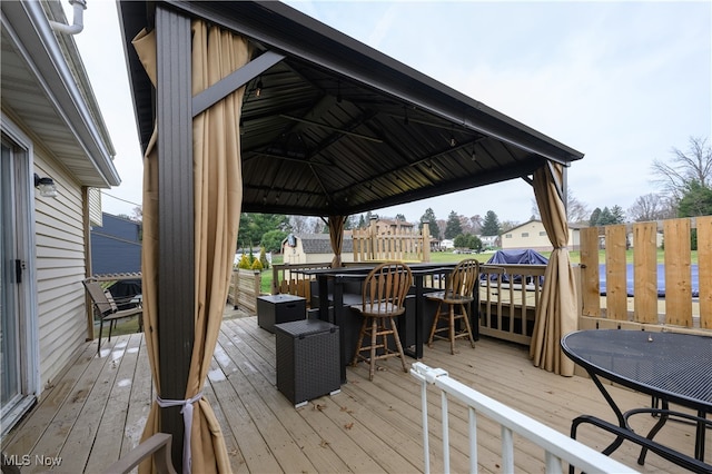 wooden deck featuring a gazebo and an outdoor bar