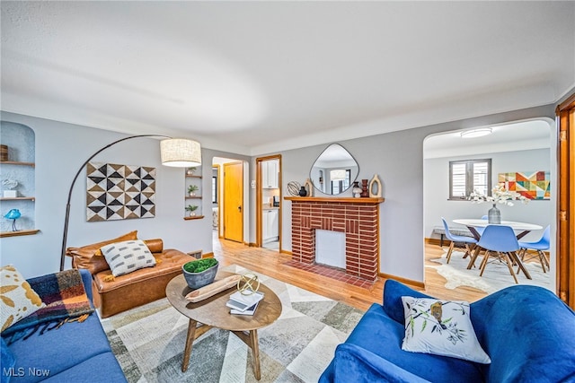 living room featuring hardwood / wood-style flooring and a brick fireplace