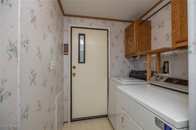 clothes washing area featuring cabinets, ornamental molding, and washing machine and clothes dryer