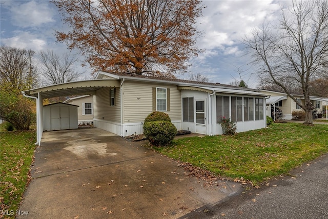 view of front facade with a storage shed, a sunroom, a front yard, and a carport