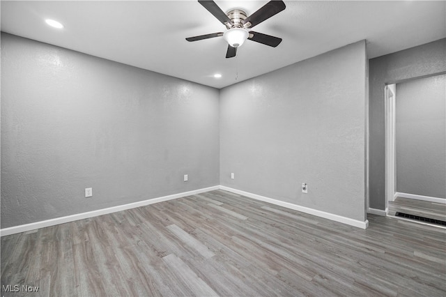 spare room with hardwood / wood-style floors and ceiling fan