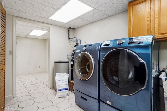 laundry room with cabinets, light tile patterned floors, and washing machine and dryer