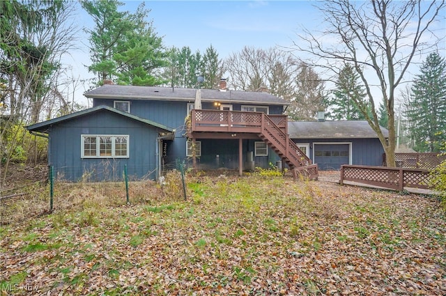 back of house with a garage and a wooden deck