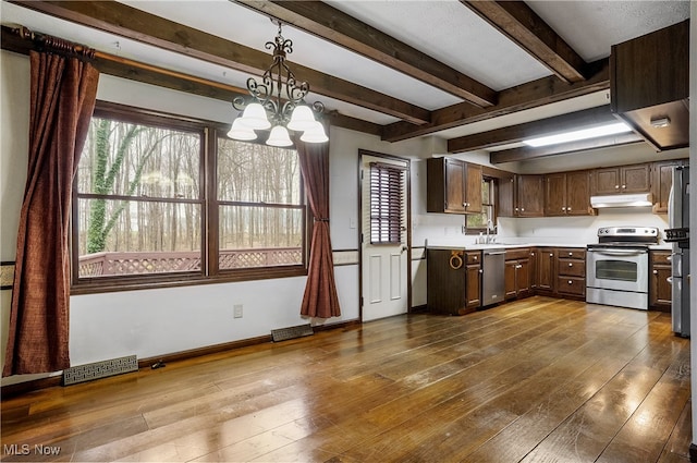 kitchen featuring stainless steel appliances, pendant lighting, beam ceiling, hardwood / wood-style flooring, and a notable chandelier