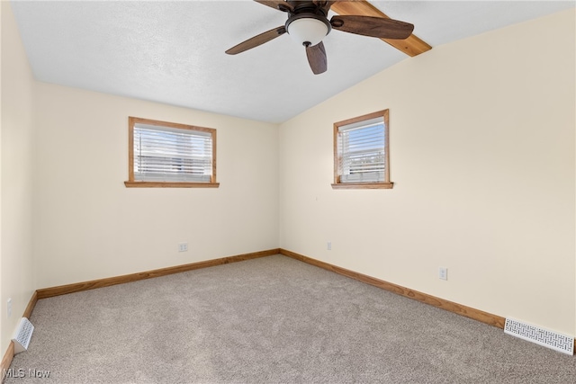 carpeted spare room featuring ceiling fan, lofted ceiling, and a textured ceiling