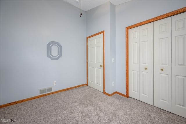 unfurnished bedroom with light carpet and a closet