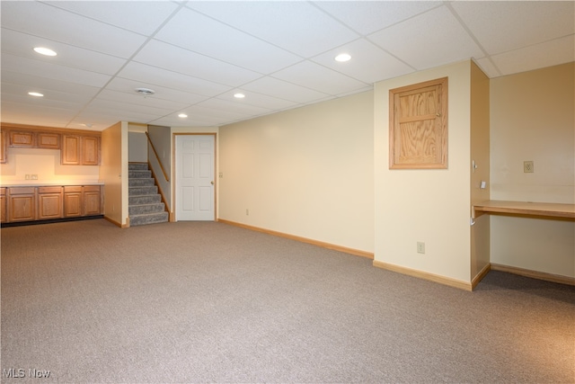 basement featuring a drop ceiling and carpet floors