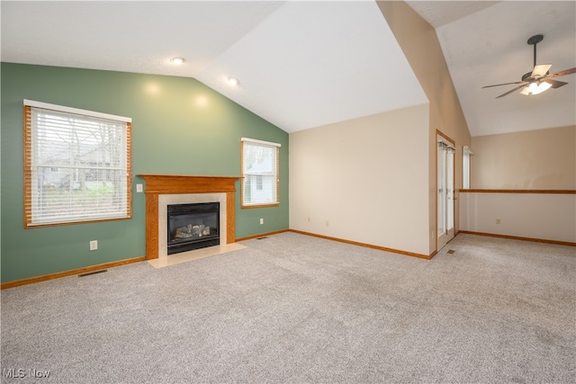 unfurnished living room with light colored carpet, a healthy amount of sunlight, and vaulted ceiling