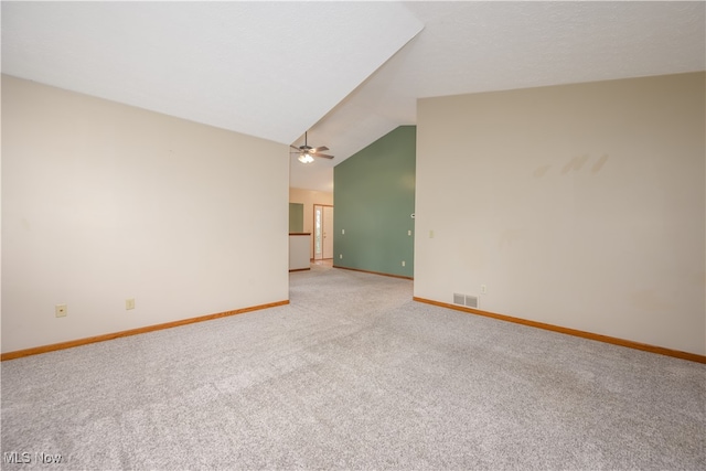 spare room featuring light colored carpet and lofted ceiling