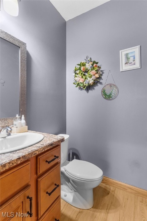 bathroom featuring hardwood / wood-style floors, vanity, and toilet