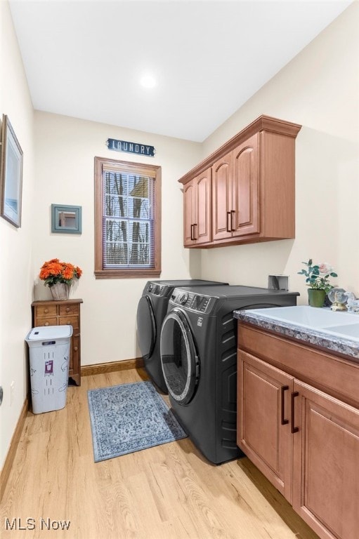 washroom featuring cabinets, independent washer and dryer, and light hardwood / wood-style floors