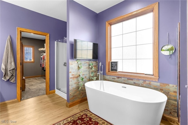 bathroom featuring independent shower and bath, plenty of natural light, and hardwood / wood-style floors