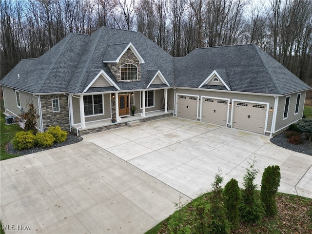 view of front of property with central AC, covered porch, and a garage