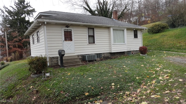 exterior space with central AC and a lawn