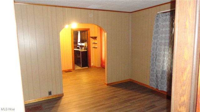 spare room featuring wood-type flooring and wooden walls