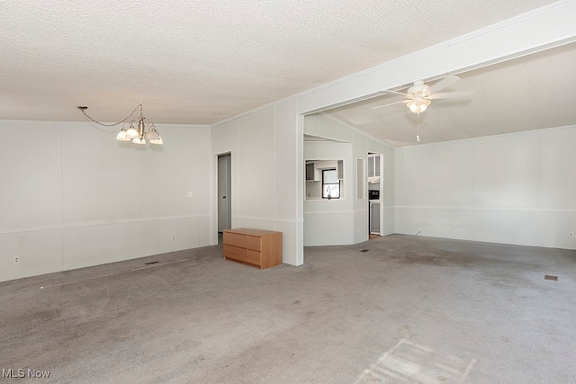 empty room featuring a textured ceiling, ceiling fan with notable chandelier, lofted ceiling, and carpet