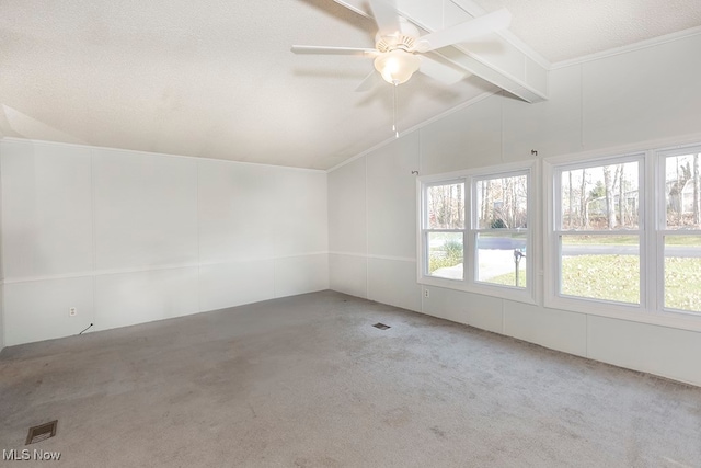 empty room featuring ceiling fan, carpet, lofted ceiling with beams, and a textured ceiling