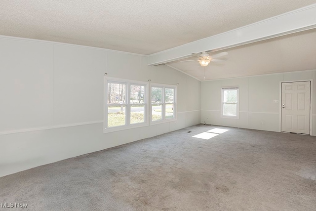 spare room with vaulted ceiling with beams, ceiling fan, carpet floors, and a textured ceiling