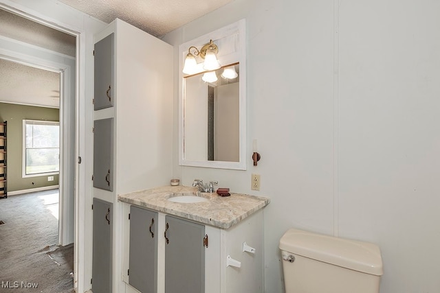 bathroom with vanity, a textured ceiling, and toilet