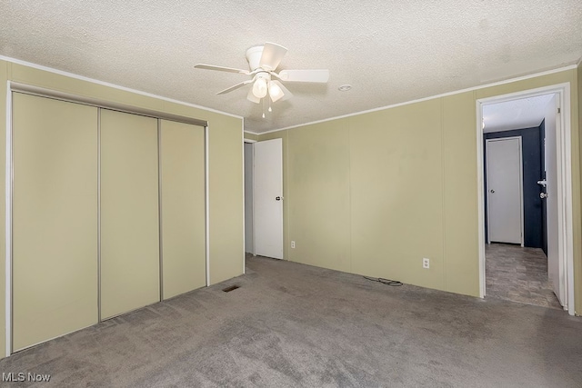 unfurnished bedroom featuring ceiling fan, a closet, light carpet, and a textured ceiling