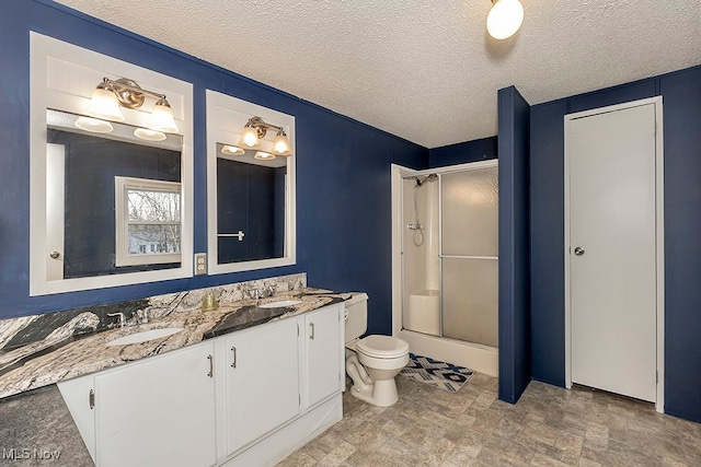 bathroom featuring vanity, a textured ceiling, and walk in shower