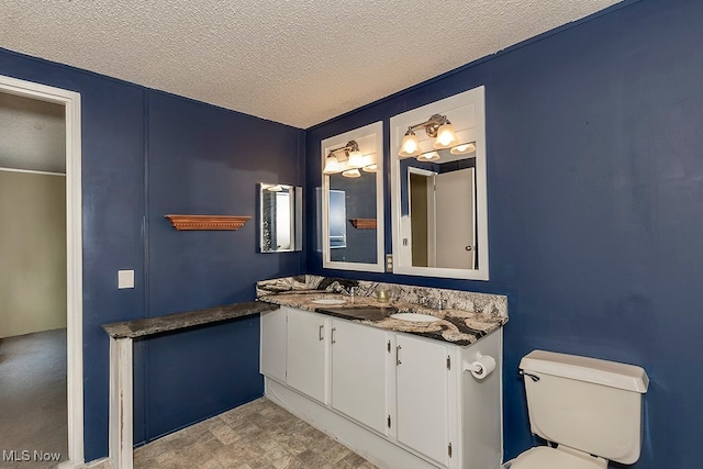 bathroom with vanity, a textured ceiling, and toilet