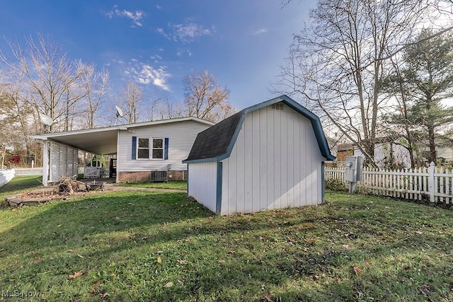 exterior space featuring a lawn, central air condition unit, and a carport