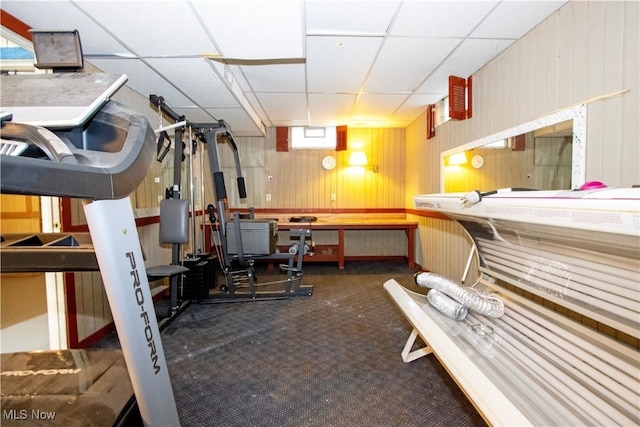 exercise area with a drop ceiling and dark carpet