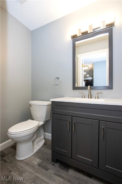 bathroom featuring hardwood / wood-style floors, vanity, and toilet