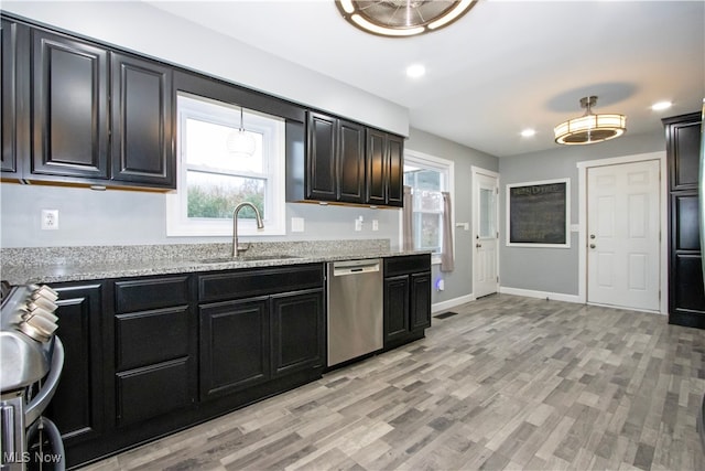 kitchen featuring sink, light stone countertops, stainless steel appliances, and light hardwood / wood-style flooring