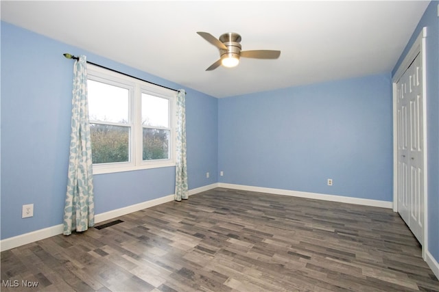 unfurnished bedroom with ceiling fan, dark hardwood / wood-style flooring, and a closet