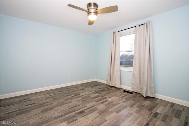 spare room with ceiling fan and dark wood-type flooring