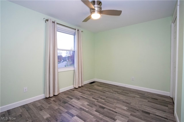 spare room with ceiling fan and dark hardwood / wood-style flooring