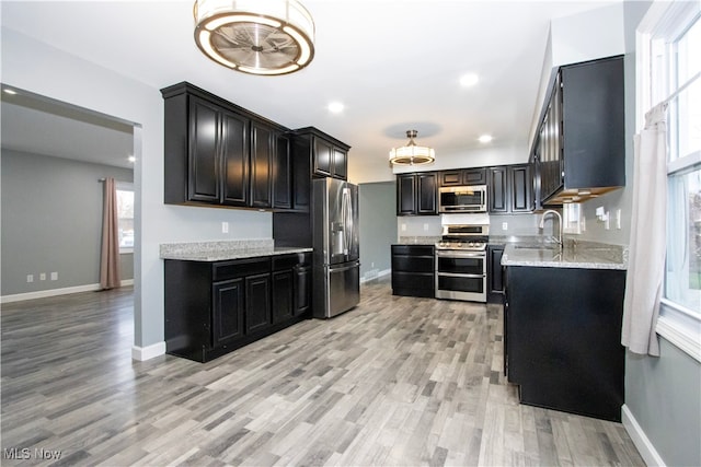 kitchen featuring a healthy amount of sunlight, sink, stainless steel appliances, and light hardwood / wood-style floors