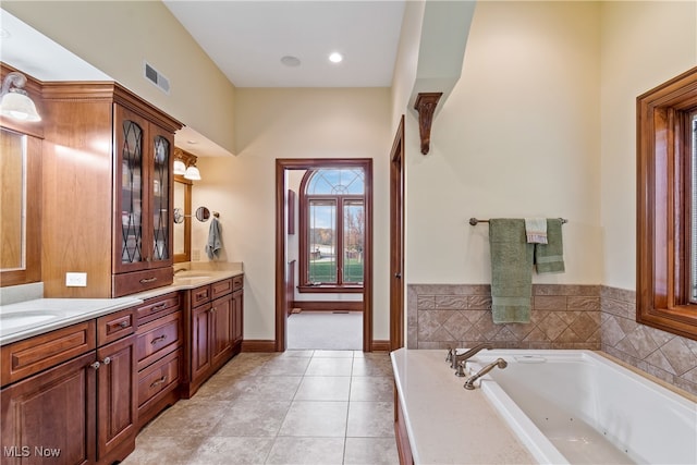 bathroom with tile patterned floors, vanity, and a tub